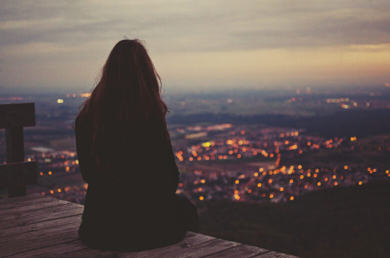 Hình ảnh cô gái ngồi một mình nhìn thành phố