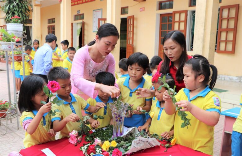 Hình ảnh cô giáo và học sinh cùng cắm hoa